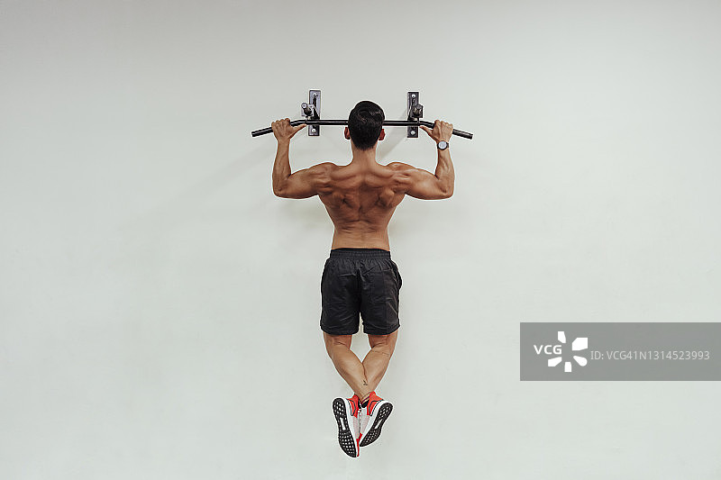 中年运动员使用器械做引体向上图片素材