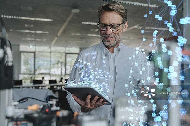 微笑男工程师使用数码平板电脑进行网络项目工作图片素材