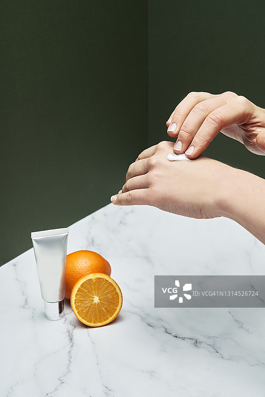 在云石桌旁涂抹护手霜的白人女性图片素材