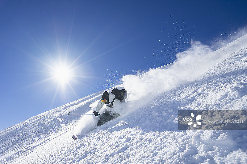 阳光下在阿尔贝格山滑雪的年轻人图片素材