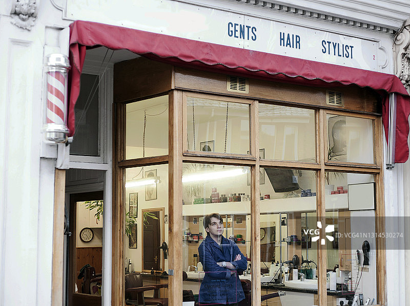 理发师在理发店透过窗户向外看图片素材