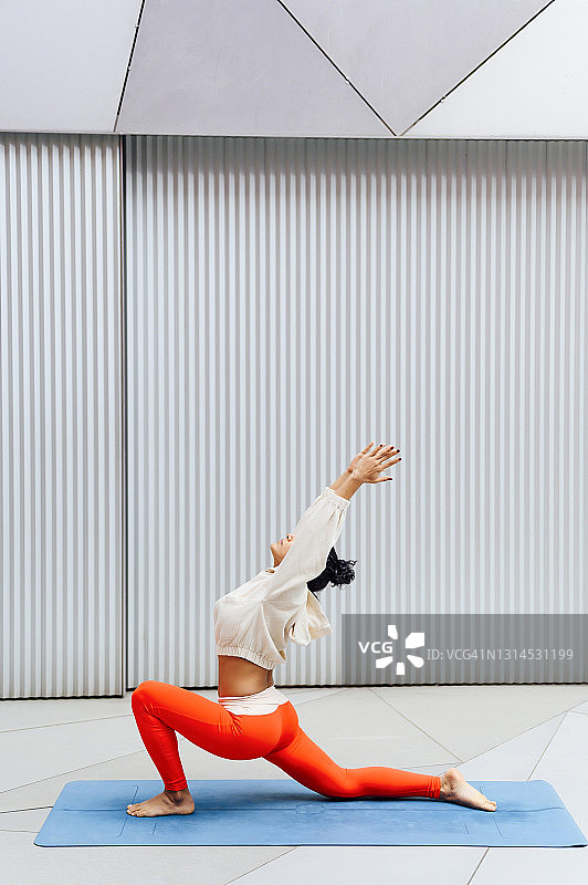 在运动垫上做后弯姿势的女运动员图片素材