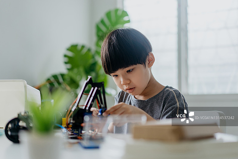 在家拼装机器人玩具的男孩图片素材