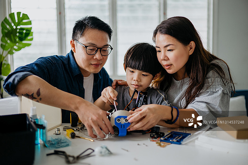 中国家庭在家一起组装机器人玩具图片素材