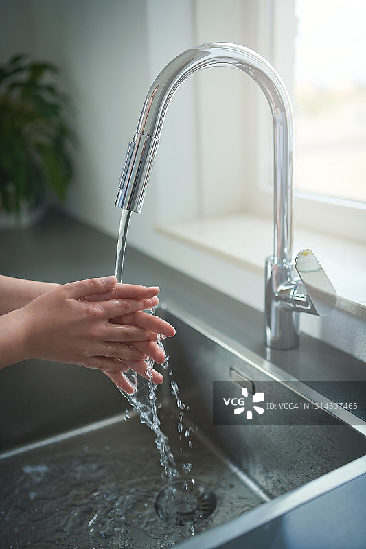 在家中厨房水槽洗手的女士图片素材