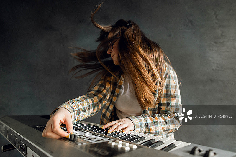 年轻女子弹奏合成器图片素材