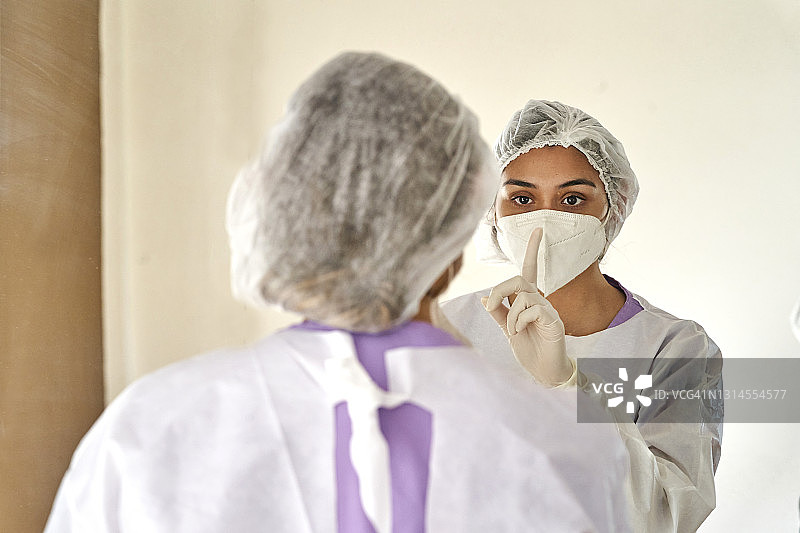 女医生用手做出闭嘴的手势图片素材