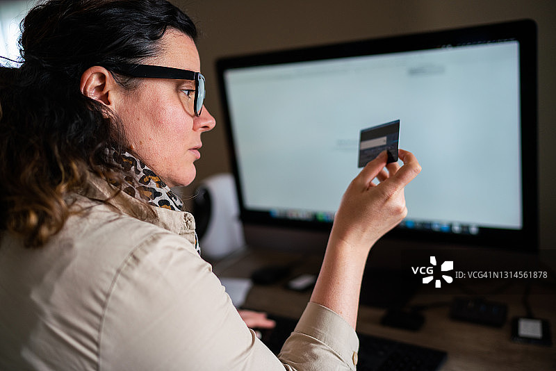 一位正在用信用卡进行网上购物的女人特写图片素材