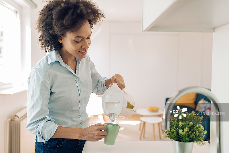 快乐的女人在上班前准备早咖啡图片素材