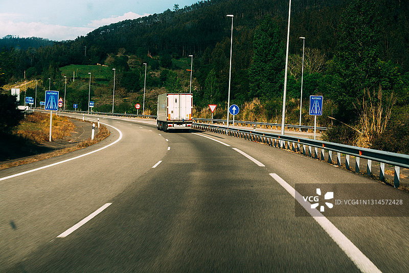 高速公路上白色铰接式卡车的后视图图片素材