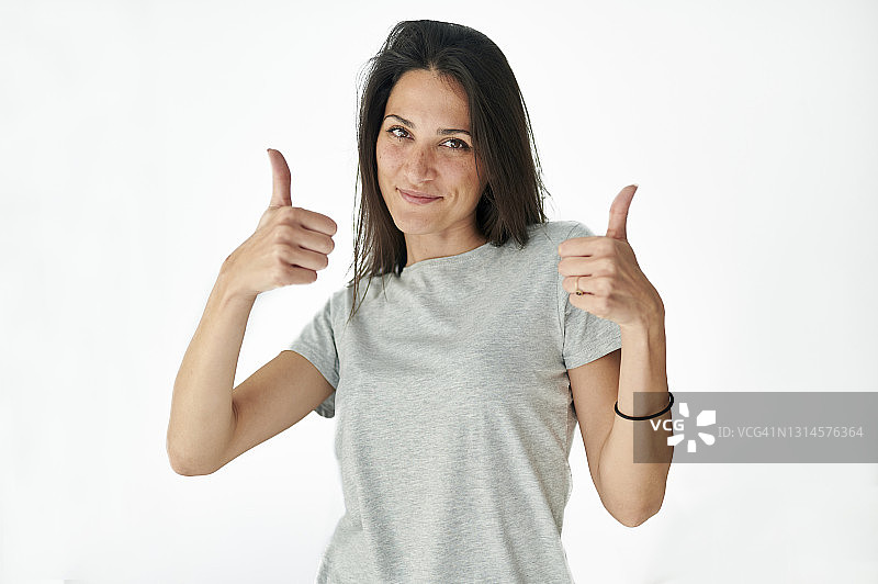 在白色背景下手势胜利的女人肖像图片素材