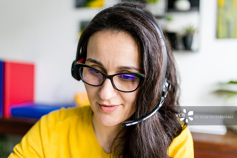 佩戴麦克风耳机的愉悦美丽微笑女士图片素材