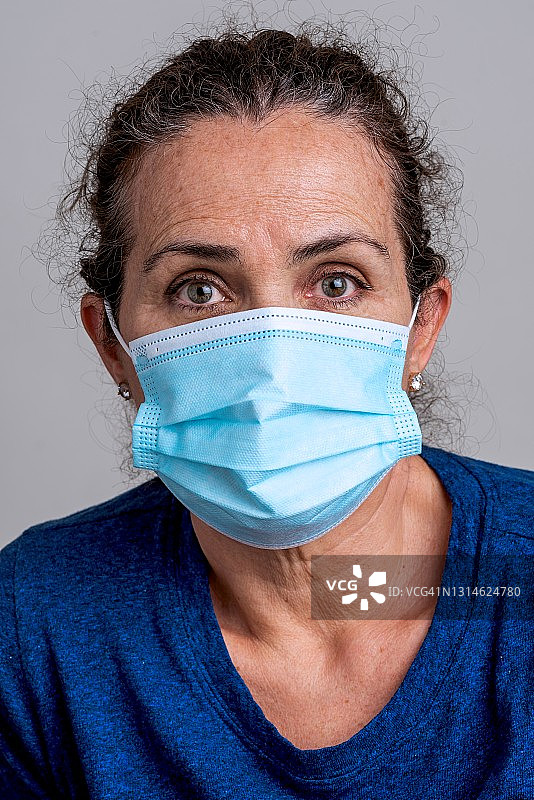 戴着防护口罩看着镜头的年长的白人女性图片素材