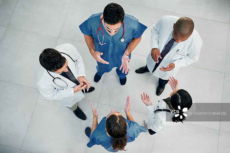 医院里一群医生围成一圈聊天的高角度照片图片素材