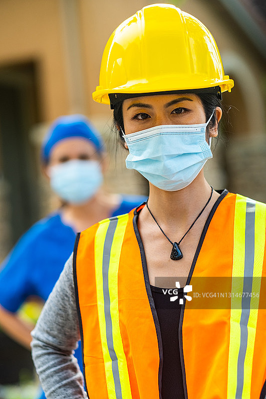 佩戴防护头盔和口罩的中年女 работники图片素材