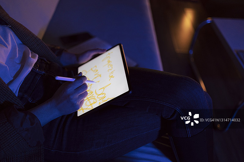 用手写笔在平板电脑上绘画的无脸女人图片素材