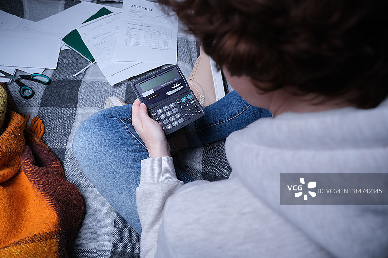 女人坐在沙发上计算家庭财务图片素材