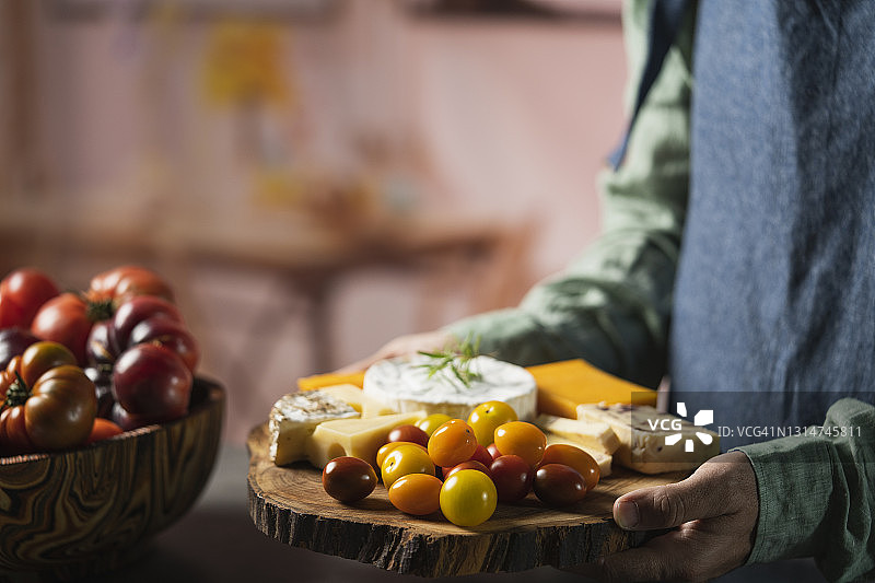 一名男子手持奶酪板图片素材