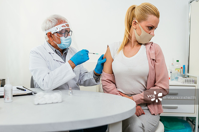 新冠疫情期间在医疗诊所接种疫苗的女病人图片素材