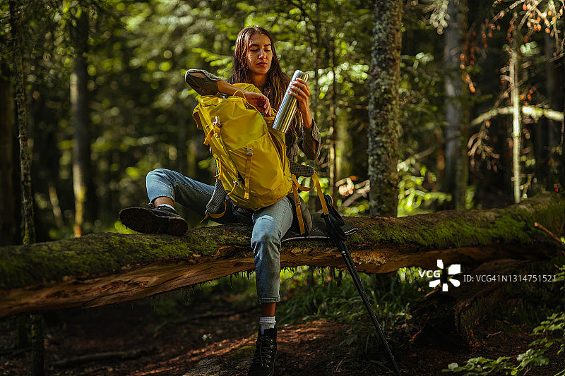 打开包裹并坐在圆木上的女人图片素材