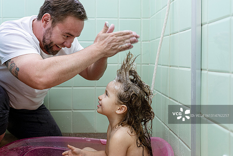 父亲在浴室里给女儿梳头发图片素材