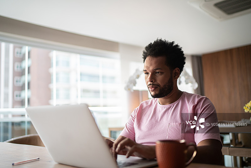在家工作使用笔记本电脑的男人图片素材