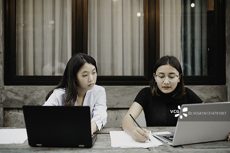 快乐的亚洲少女使用笔记本电脑图片素材