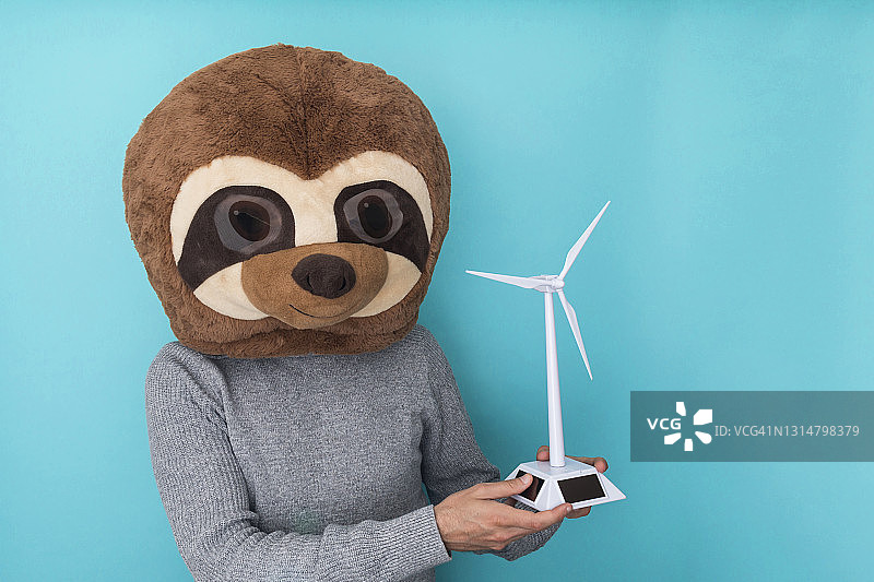 戴着猫鼬头套的男子拿着小风车图片素材