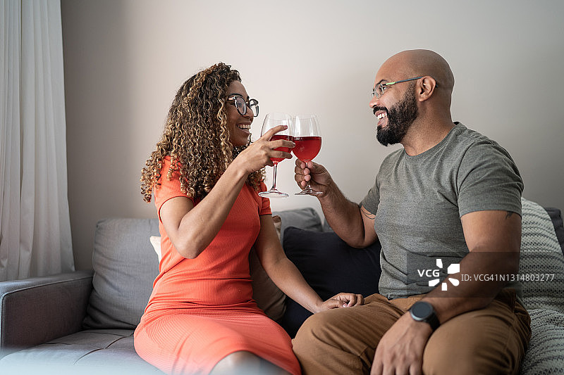 情侣在家中用酒杯碰杯图片素材