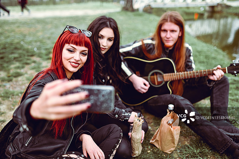 哥特风女孩与男吉他手在公园自拍图片素材