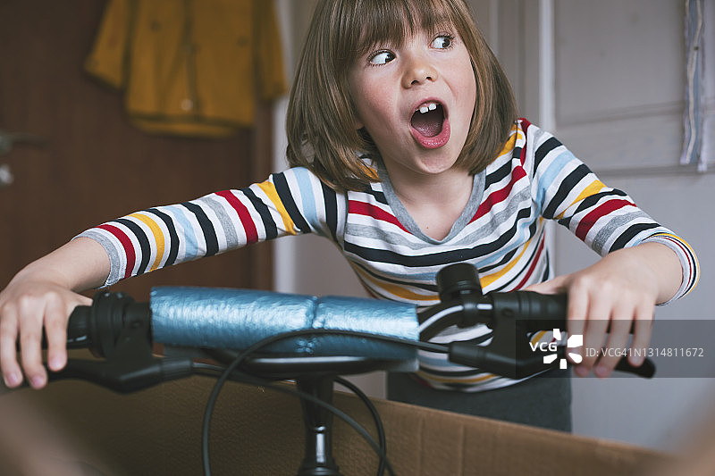 快乐男孩在网上购物后拆开新自行车图片素材