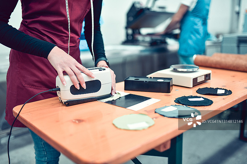 女性在纺织厂用分光光度计测量材料图片素材