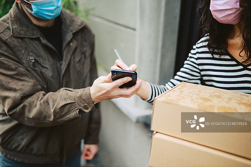 疫情期间的包裹电子签名交付图片素材