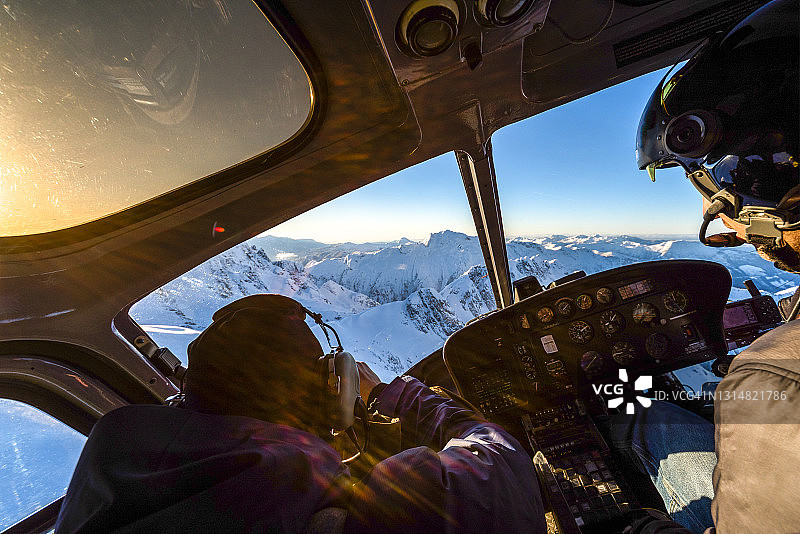 滑雪者乘直升机飞越雪山图片素材