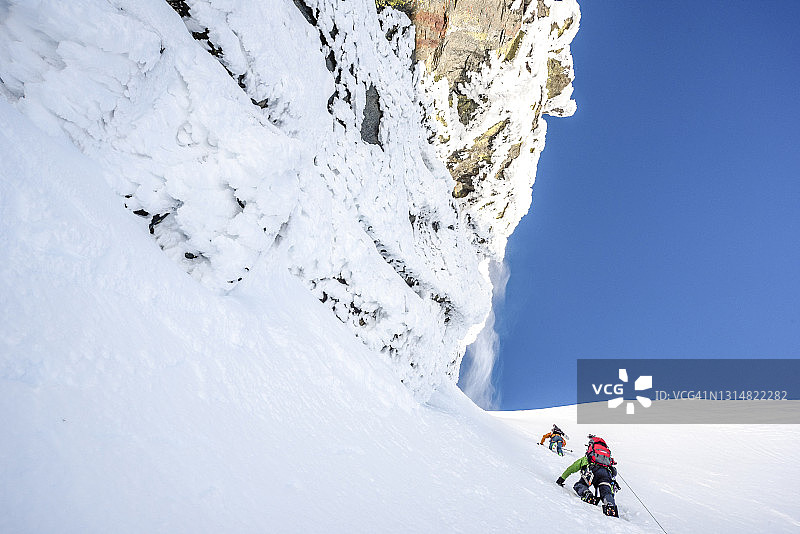 滑雪登山者攀登陡峭的山坡图片素材