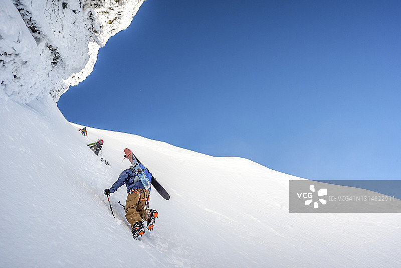 滑雪登山者攀登陡峭的山坡图片素材