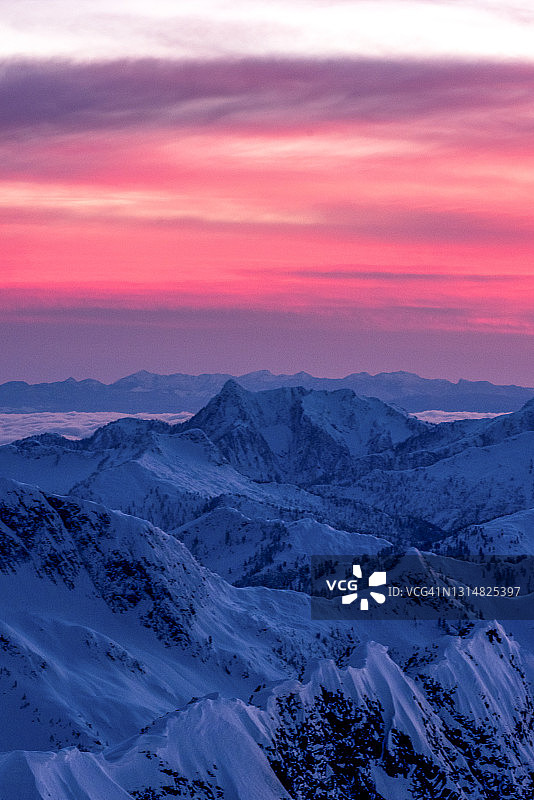 白雪皑皑的群山和云层上的日出鸟瞰图片素材