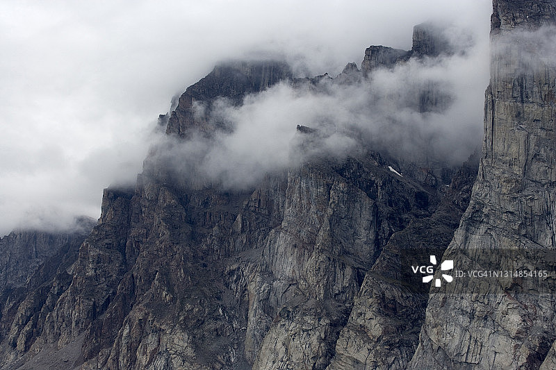 低空云层漂浮在花岗岩海岸悬崖间图片素材
