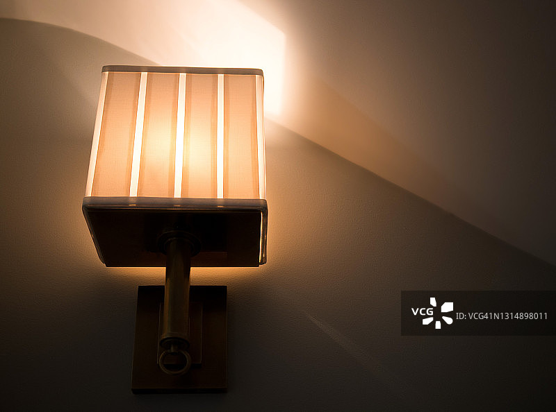 倾斜天花板下带照明的黄铜墙壁壁灯图片素材