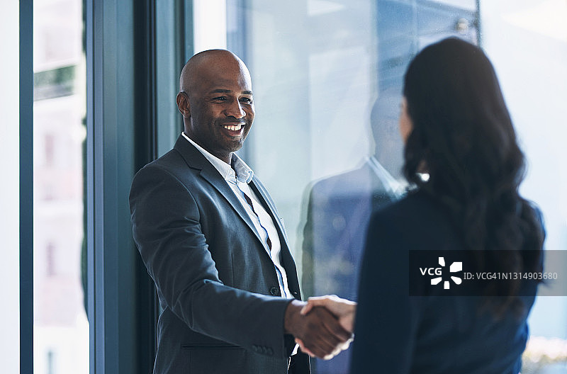 年长的商人在办公室与同事握手的镜头图片素材