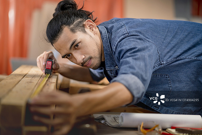 亚洲商业仓库女老板和男设计师在工作室仓库中设计和测量木工项目图片素材