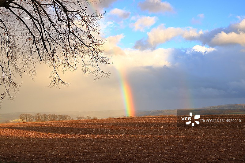 暴风雨天空中的彩虹：乡村景色图片素材
