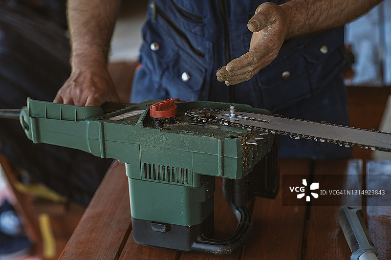 在车间更换链锯上的链条图片素材