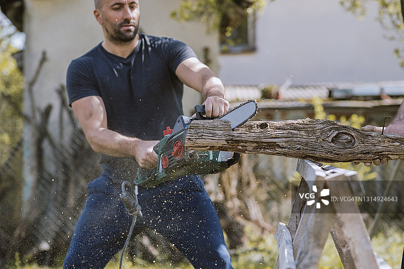 用油锯切割树干的男人图片素材