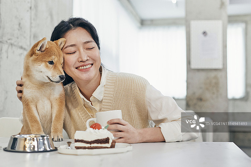 一名女子和柴犬在宠物咖啡馆图片素材