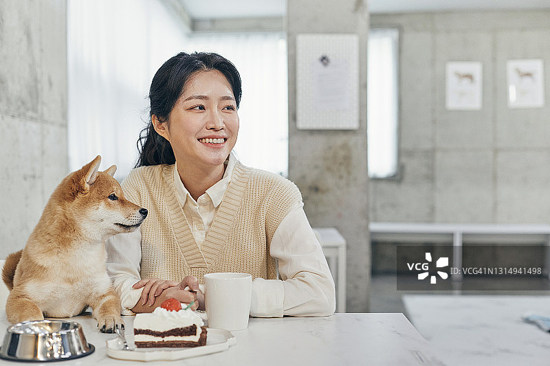 一名女子和柴犬在宠物咖啡馆图片素材