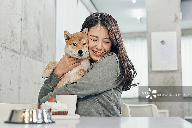 一名女子和柴犬在宠物咖啡馆图片素材