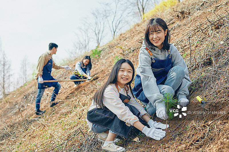 一名妇女和孩子正在种植幼苗图片素材