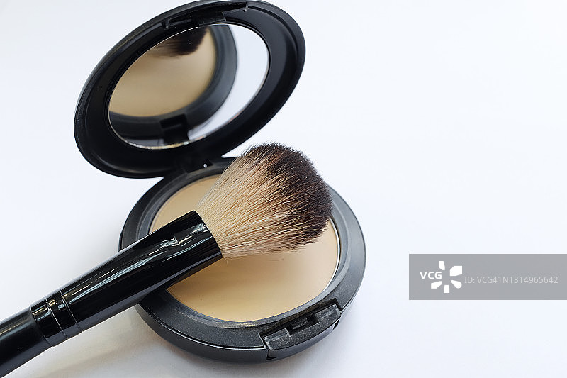 化妆刷和矿物粉饼，用于在美容院和家中进行专业化妆，白色背景上隔离。 面部和身体护理图片素材