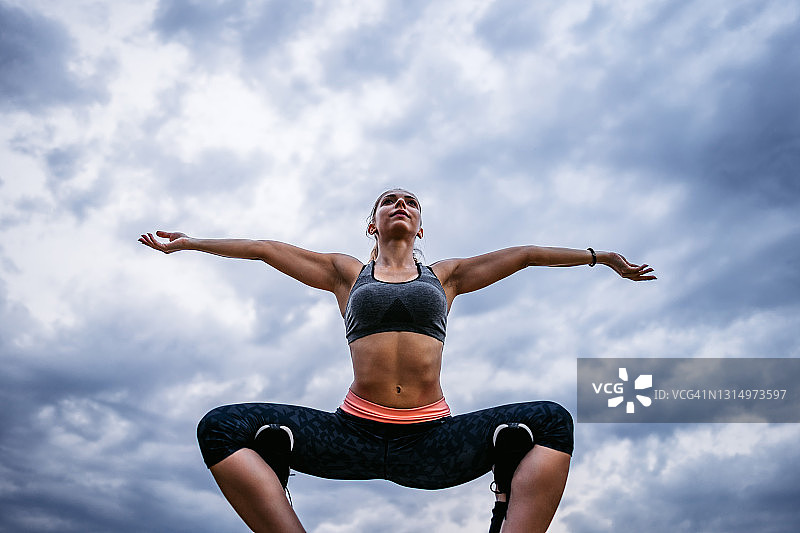 体态健美的女子在云端练习双人瑜伽图片素材